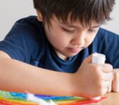 Niño usando adhesivo escolar