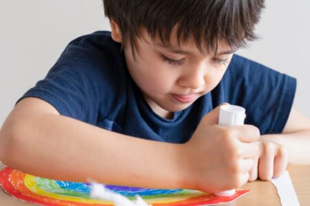 Niño usando adhesivo escolar